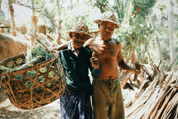 Ethnic harvesters with baskets in jungle